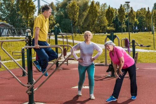 emeryci ćwiczący na siłowni plenerowej